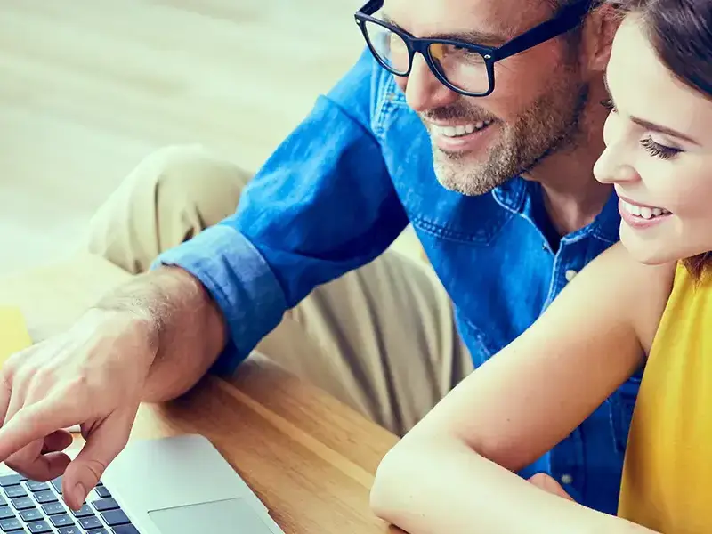 man and woman looking into laptop